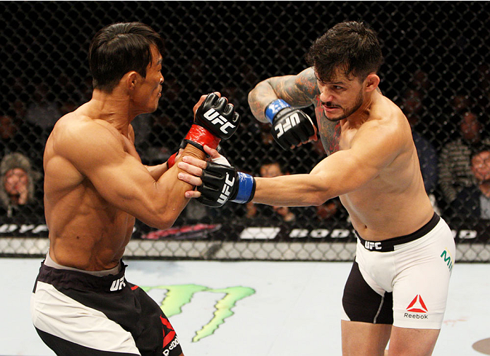 SEOUL, SOUTH KOREA - NOVEMBER 28: Alberto Mina of Brazil throws a punch at Yoshihiro Akiyama of Japan in their welterweight bout during the UFC Fight Night at the Olympic Park Gymnastics Arena on November 28, 2015 in Seoul, South Korea. (Photo by Mitch V