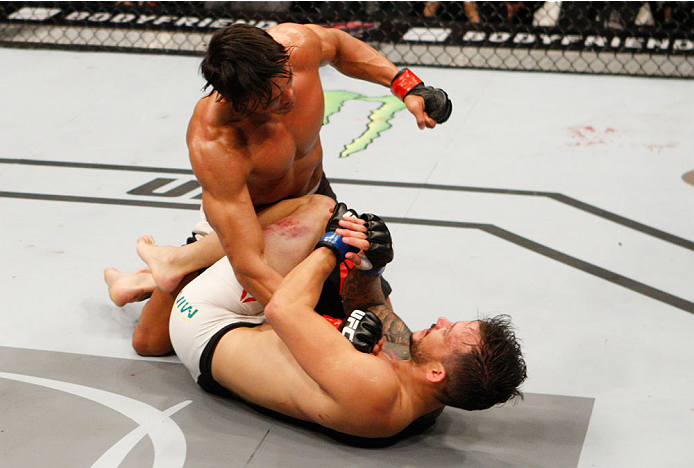 SEOUL, SOUTH KOREA - NOVEMBER 28: Yoshihiro Akiyama of Japan punches Alberto Mina of Brazil in their welterweight bout during the UFC Fight Night at the Olympic Park Gymnastics Arena on November 28, 2015 in Seoul, South Korea. (Photo by Mitch Viquez/Zuf