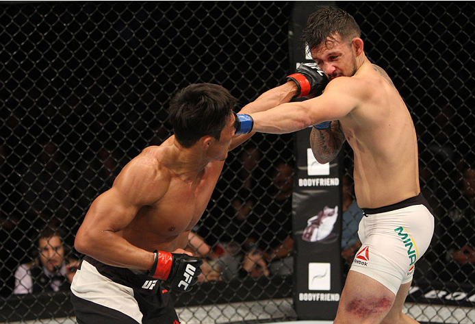 SEOUL, SOUTH KOREA - NOVEMBER 28: Yoshihiro Akiyama of Japan punches Alberto Mina of Brazil in their welterweight bout during the UFC Fight Night at the Olympic Park Gymnastics Arena on November 28, 2015 in Seoul, South Korea. (Photo by Mitch Viquez/Zuf